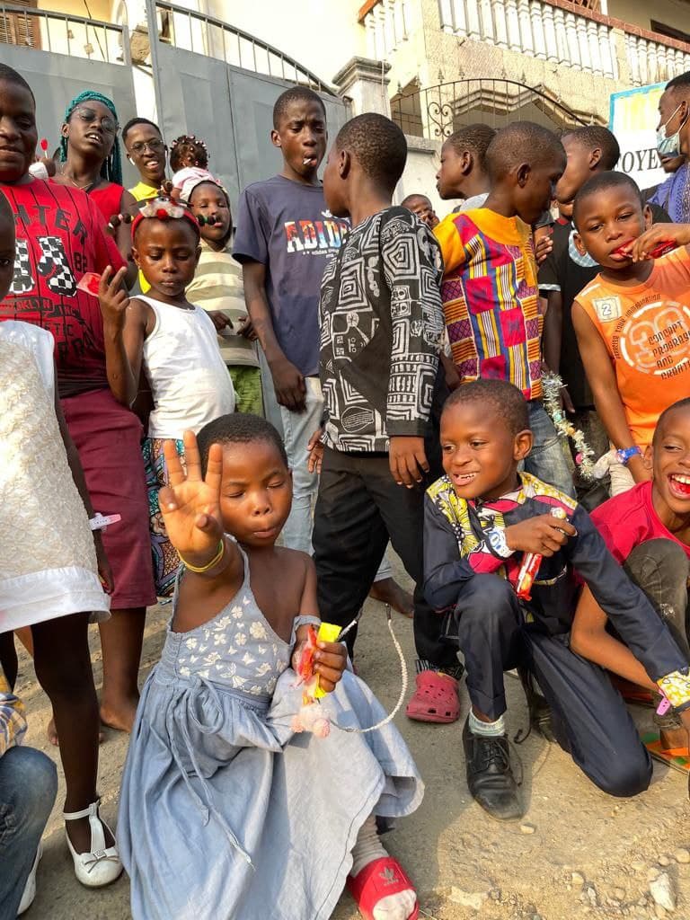 Enfant souriant tenant un cadeau lors d’une fête de Noël organisée à Douala